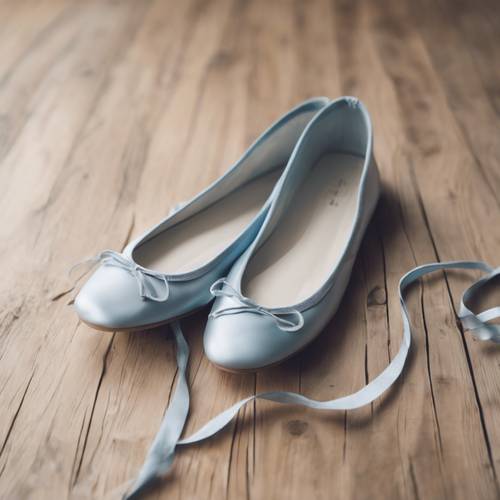Sepasang sepatu balet berwarna biru pastel diposisikan rapi di lantai kayu keras.