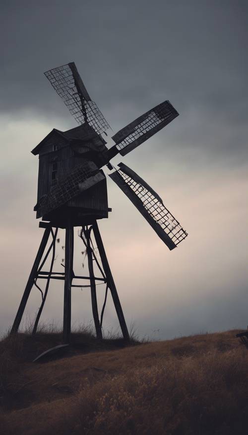 A tumble-down windmill perched on a bleak hill under the gloom of twilight. Wallpaper [30d57a1ad0bf4198802c]