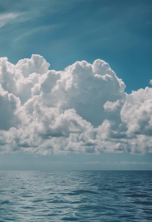 平靜的藍色海洋上空雲層的圖片。