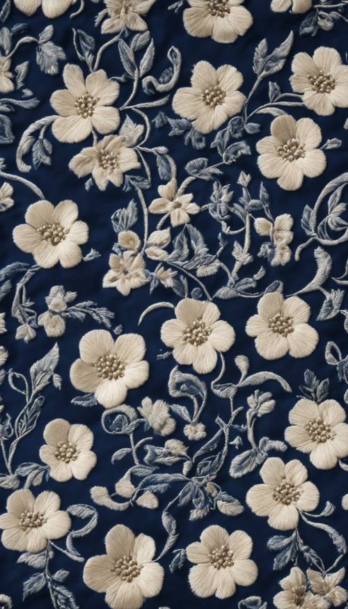 A cream floral pattern beautifully embroidered on a Victorian era-style, dark blue dress.