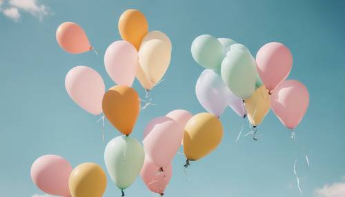 Ein Haufen pastellfarbener Luftballons in Form von fliegenden Kühen vor einem klaren Himmel.