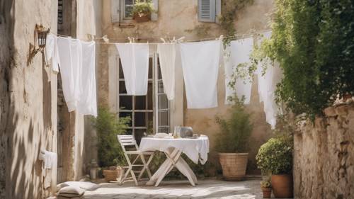 White linen drying in the cool summer breeze in a quaint courtyard, a perfect French country scene.