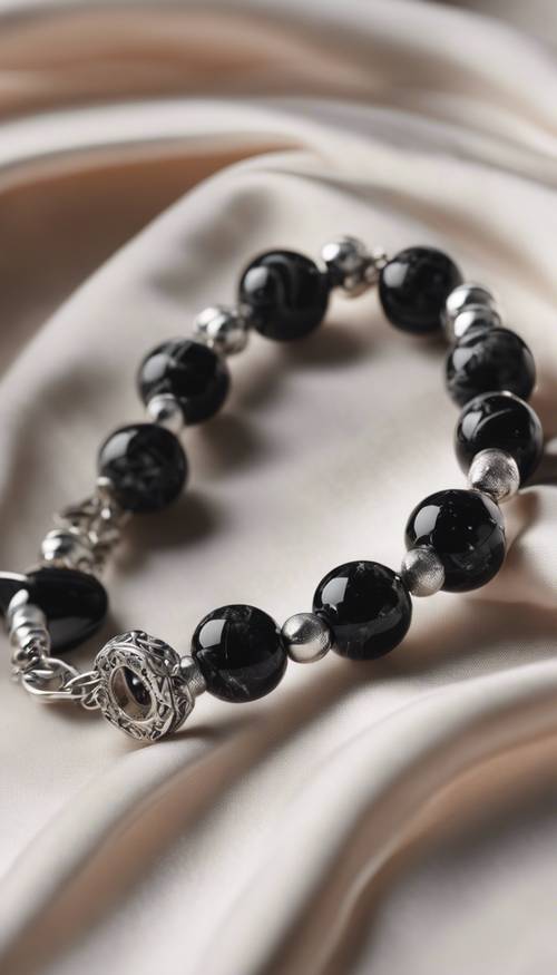 Un&#39;inquadratura ravvicinata di un braccialetto in marmo nero e argento lucido su un panno di seta.
