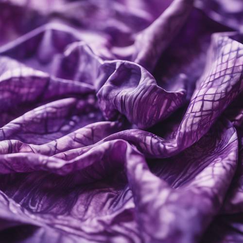 A crumpled sheet of fabric unfolding to reveal a stunning purple tie-dye design.