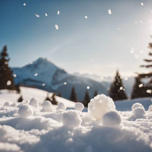 Pertarungan bola salju yang bersahabat dengan latar belakang gunung tertutup salju yang indah.