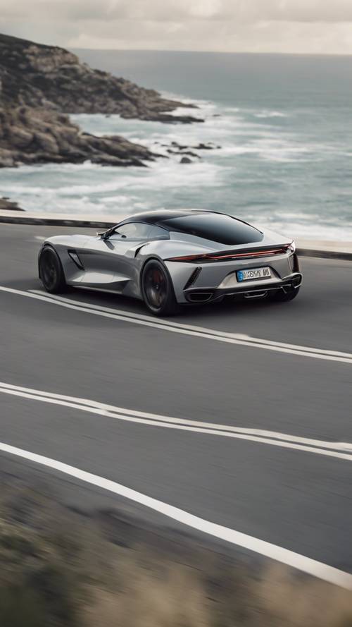 Um elegante carro esportivo cinza claro acelerando por uma estrada costeira sinuosa.