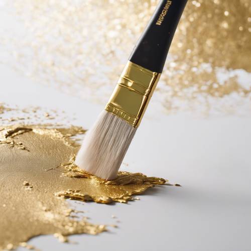 A paintbrush leaving a trail of textured, metallic gold paint on pristine white paper.