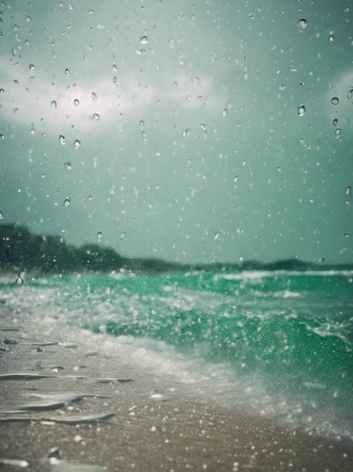 Tropikalna plaża podczas ulewnej ulewy, krople deszczu uderzające w szmaragdową powierzchnię oceanu.