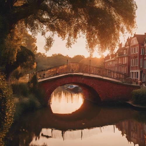 Jembatan bata merah melengkung anggun di atas kanal yang tenang saat matahari terbenam.