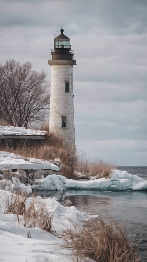 A rustic lighthouse standing majestically on the icy shores of Lake Michigan during the throes of winter.