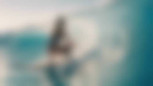一名女子身着炫酷的冲浪装，在湛蓝的海浪中驰骋，享受着冲浪的刺激。