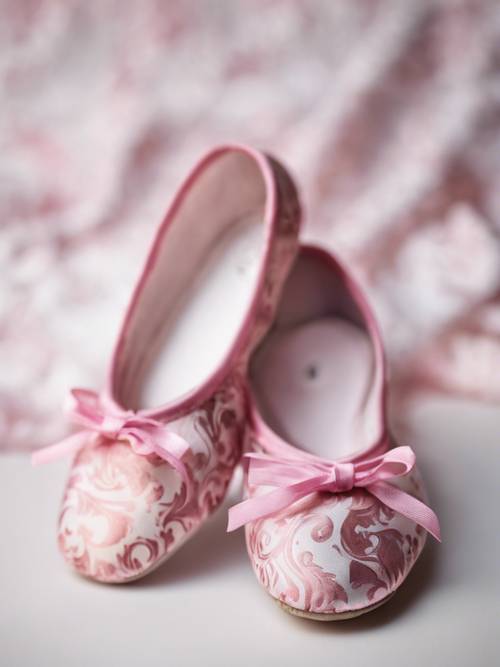 Un par de zapatillas de ballet con estampado de damasco rosa sobre un fondo blanco.