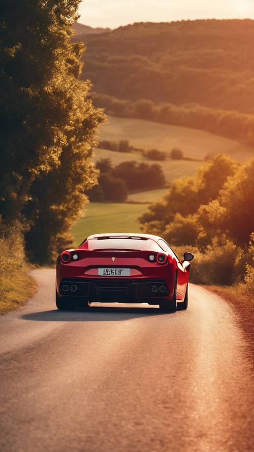 Ferrari merah cerah melaju di jalan pedesaan yang berkelok-kelok saat matahari terbenam.
