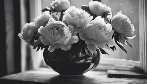 A still life arrangement of black and white peonies in a vintage vase.
