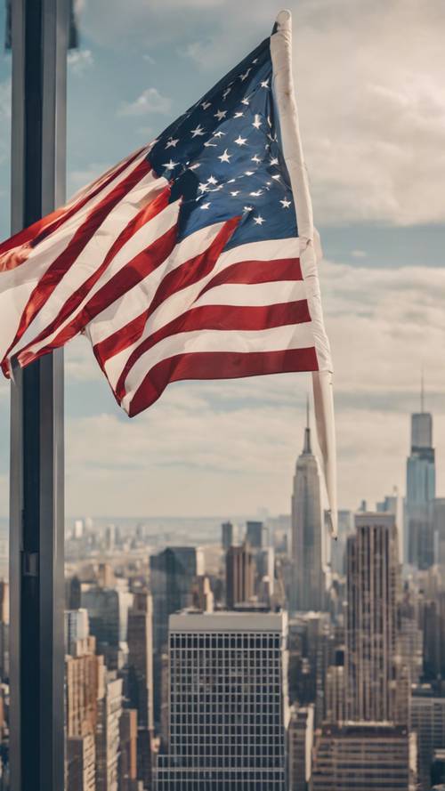דגל אמריקאי ענק מתנופף ברוח עם נוף עירוני ברקע.