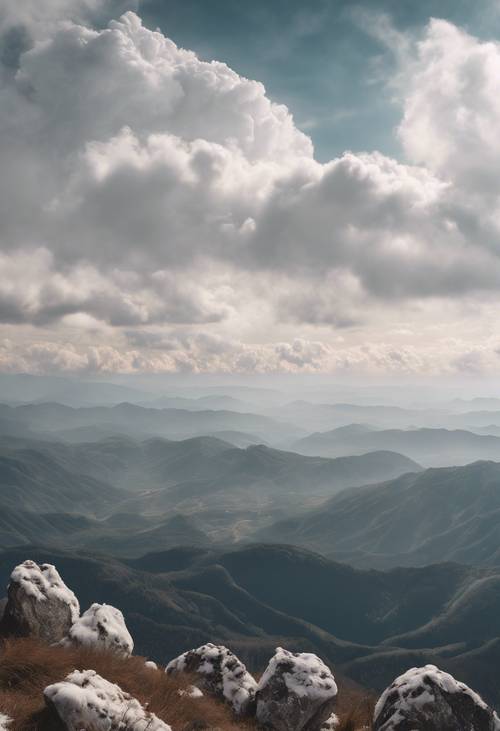 Uma vista do topo de uma montanha com nuvens brancas permanecendo abaixo.
