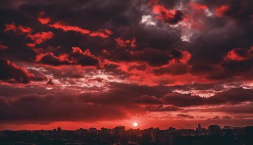 Piękny zachód słońca z odcieniami czerwieni i czerni rzucającymi intensywne cienie na gromadzące się chmury.