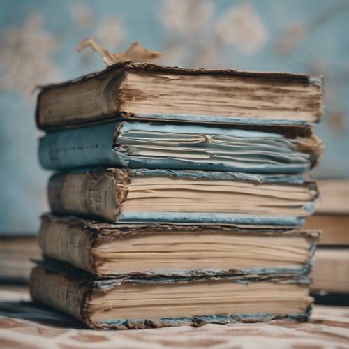 An old set of books with worn-out baby blue covers stacked upon each other.