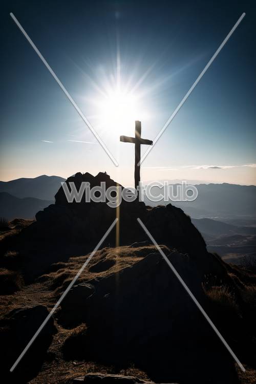 Залитый солнцем крест на вершине горы