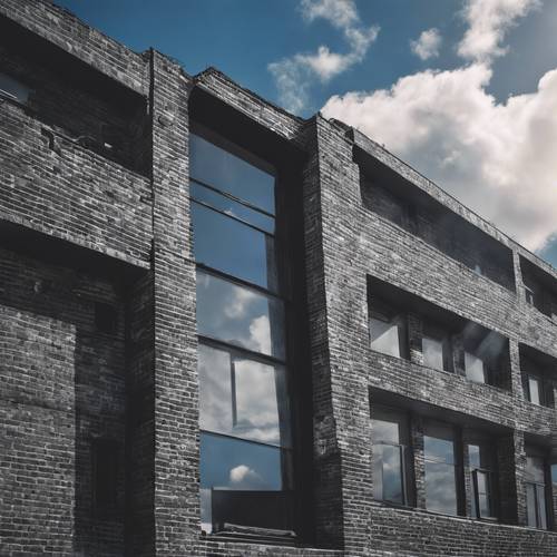 Un bâtiment en briques noires et grises par une journée ensoleillée avec un ciel bleu profond.