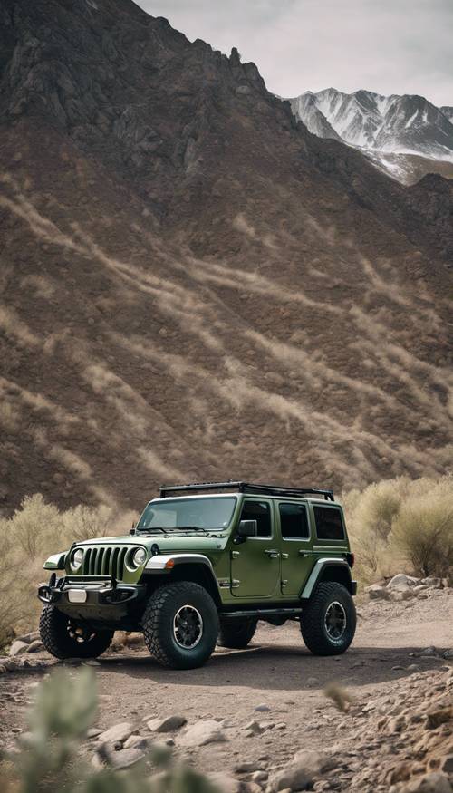 Jeep Wrangler berwarna hijau bijak, bodinya dipoles dan berkilau, diparkir di luar jalan raya dengan latar belakang pegunungan terjal. Wallpaper [9f6d17e5c2d3400dadb6]