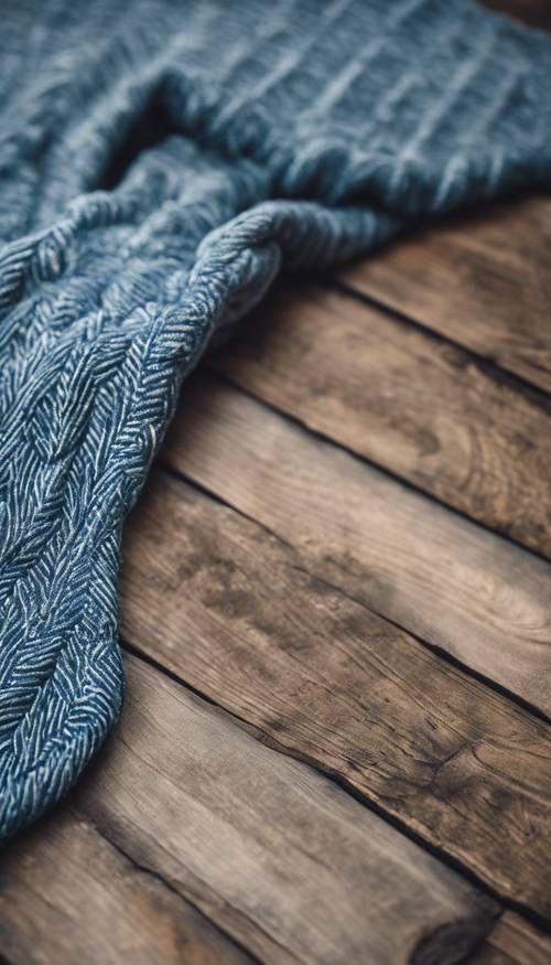 A Recently-made blue herringbone throw rug on a rustic wooden floor.