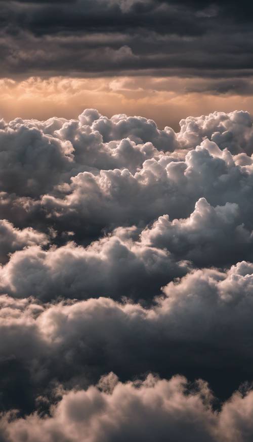 שמיים מעוננים מלאים בעננים לבנים רכים על רקע אופק שחור במהלך הדמדומים.