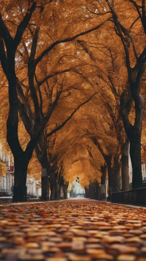 An old cobblestone street lined with trees bearing bold, autumn colors.