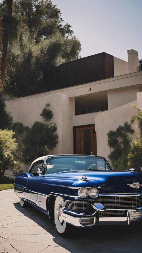 Un Cadillac clásico azul real estacionado en la entrada de una casa moderna de mediados de siglo.