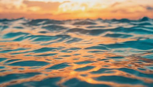 Krystalicznie czysty tropikalny ocean odbijający turkusowe niebo o zachodzie słońca.