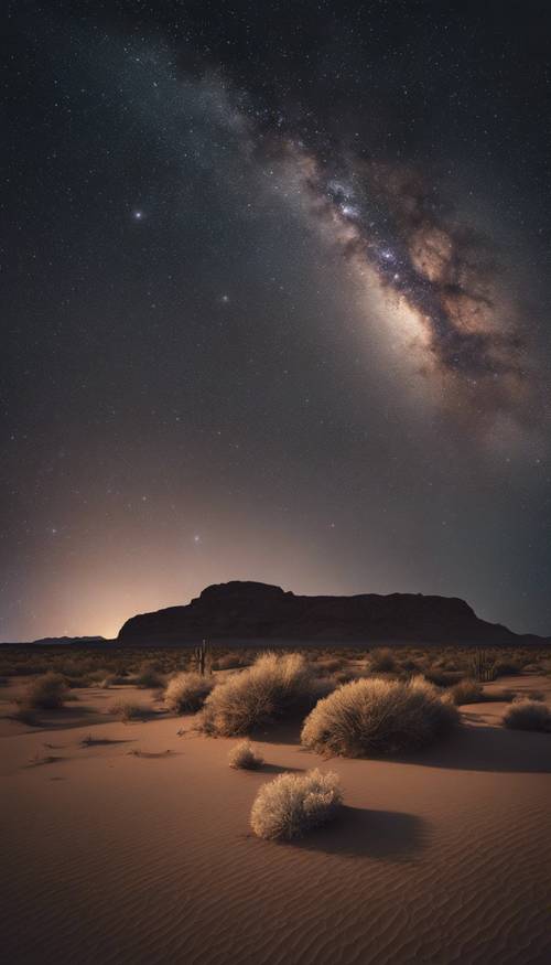 A starlit night in the desert, with a vibrant Milky Way stretching across the scene.