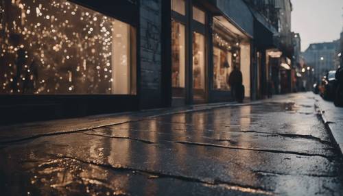 傍晚燈光下的店面，在濕漉漉的柏油路上投射出灰色的、閃閃發光的影子。