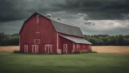 Une grange rouge classique sur un ciel gris et orageux.