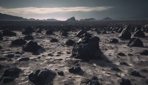 Rocas negras irregulares que se extienden hacia el horizonte en un desolado paisaje lunar.