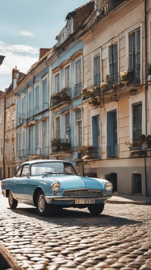 Un coche antiguo de color azul claro estacionado en una calle adoquinada iluminada por el sol.