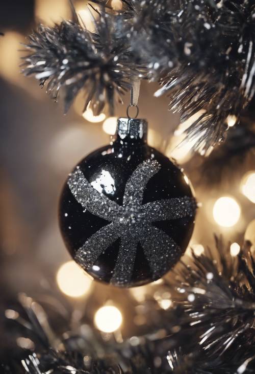 검은색과 은색으로 반짝이는 반짝이는 장식품이 크리스마스 트리에 매달려 있습니다.