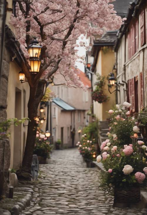 A quaint cobblestone street adorned with lanterns and lined with vintage houses each with a blooming spring garden.