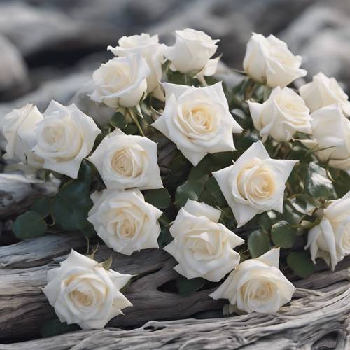 A cluster of white roses cast over a rugged sea-washed driftwood on a pebbly beach. Tapeta [b4071297e1e742b7a0b5]