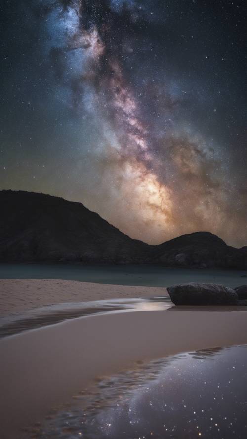 Vista della Via Lattea attraverso un cielo notturno stellato scuro visto da una spiaggia deserta.