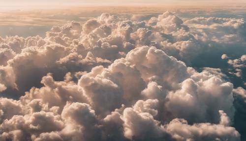 Dalgalı bej bulutları gösteren bir uçağın penceresinden görünüm.
