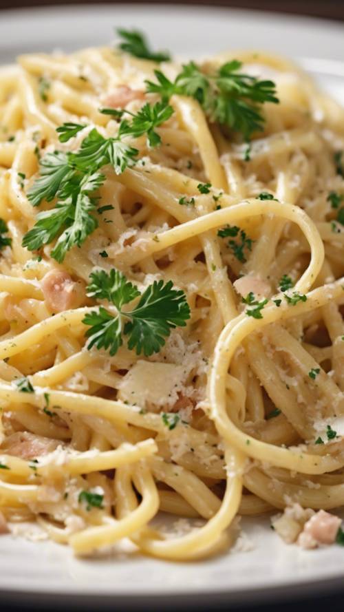Zbliżenie na spaghetti carbonara podawane na białym talerzu, posypane świeżą pietruszką i tartym parmezanem. Tapeta [17a4877f278444f687ff]