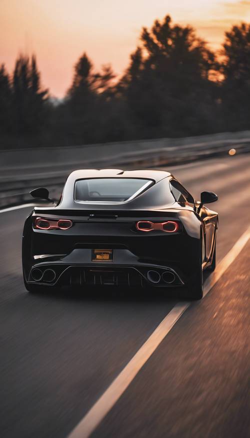 A sleek black sports car zooming down an empty highway at dusk