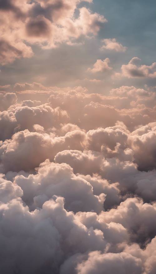 Pemandangan awan halus di pagi hari, diwarnai dengan cahaya fajar pertama, menyebar melintasi langit yang tenang.