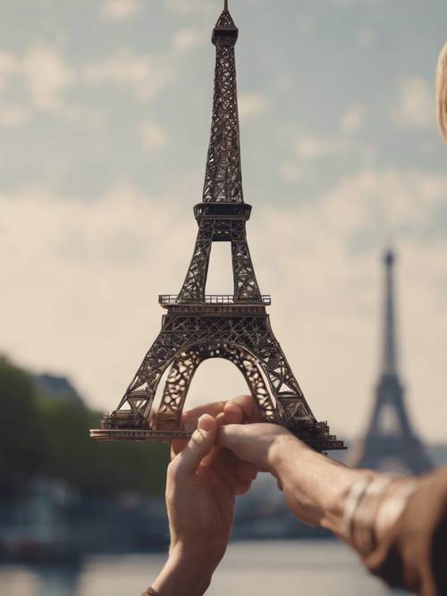 A chain of human hands holding a miniature replica of the Eiffel Tower.