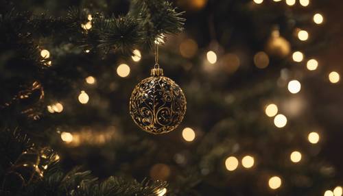 An obscure black and gold glass ball hanging on a rustic, half-decorated Christmas tree in a dimly-lit room.