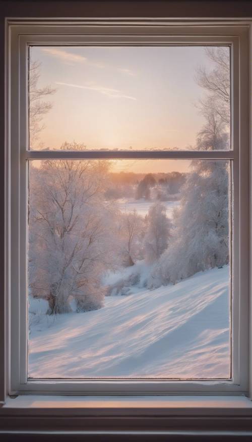 눈 덮인 풍경에 부드러운 파스텔 색조를 드리우고 있는 오두막 창문에서 보이는 쌀쌀한 겨울의 일출입니다.