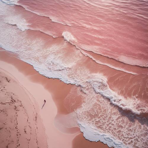 분홍색 모래 해변의 공중 전망과 파도가 해안을 덮치고 있습니다.