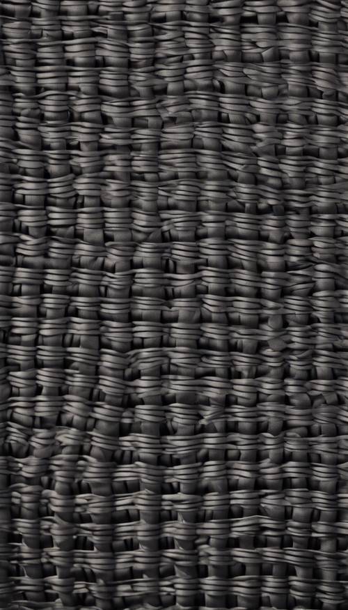 A close-up texture of woven carbon fibre material.