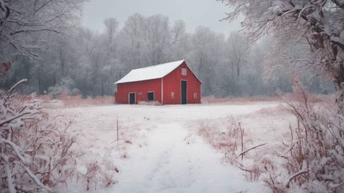 Gudang pedesaan dicat merah di bawah hujan salju lembut di pedesaan.