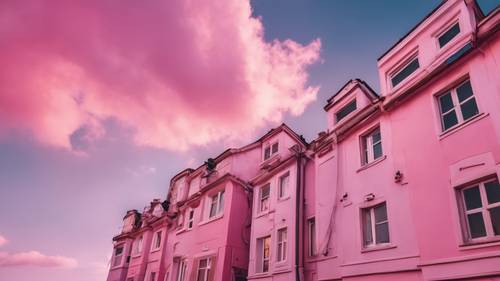 Windows of illuminated houses under a sky packed with pink clouds.